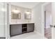 Modern bathroom features gray dual vanity, two mirrors, stylish lighting, and glass shower with patterned flooring at 870 Gaston Sw St, Atlanta, GA 30310