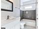 Well lit bathroom features a framed mirror, stylish vanity, and a tiled shower-tub with matching tile flooring at 870 Gaston Sw St, Atlanta, GA 30310
