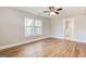 Light filled bedroom features hardwood floors, a ceiling fan, and two windows with closet and bathroom access at 870 Gaston Sw St, Atlanta, GA 30310