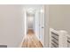 Well-lit hallway features hardwood floors, neutral paint, and a row of white doors, leading to various rooms at 870 Gaston Sw St, Atlanta, GA 30310