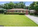 Charming brick home with a well-maintained lawn and mature landscaping at 135 5Th Ave, Jonesboro, GA 30236