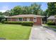 Charming brick home with a well-maintained lawn and mature landscaping at 135 5Th Ave, Jonesboro, GA 30236