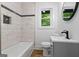 Bathroom featuring marble-look tile surround the bathtub, a modern vanity, and a large mirror at 1400 North Avenue Nw, Atlanta, GA 30318