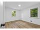 Bright bedroom with hardwood floors, white walls, and two windows overlooking green trees at 1400 North Avenue Nw, Atlanta, GA 30318