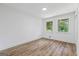 Bedroom with wood-look floors, white walls, and windows that overlook green trees at 1400 North Avenue Nw, Atlanta, GA 30318