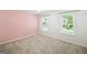 Bedroom featuring pink accent wall, carpet, and natural lighting from two windows at 3506 Billingsley Dr, Marietta, GA 30062