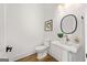 Powder room featuring a white pedestal sink, round mirror, and neutral decor at 1836 Memorial Dr # 303, Atlanta, GA 30317