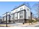 Modern townhome with a two-car garage and mixed material exterior, including light gray siding and brick at 1836 Memorial Dr # 303, Atlanta, GA 30317