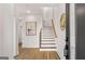 Hallway with hardwood floors leading to staircase with light wood treads and gold accents at 1836 Memorial Dr # 303, Atlanta, GA 30317