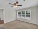 Well-lit room with neutral carpet, ceiling fan, and window providing a view of the outdoors at 79 The Farm Rd, Mcdonough, GA 30252