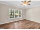 Sunny bedroom with ceiling fan, wood grain flooring, and a large window with natural light at 79 The Farm Rd, Mcdonough, GA 30252