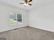 Bright bedroom with a ceiling fan, neutral carpet, and a window with a view of the backyard at 79 The Farm Rd, Mcdonough, GA 30252
