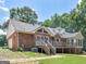 Rear exterior of brick home with back deck and lush trees in backyard at 79 The Farm Rd, Mcdonough, GA 30252