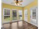 Sunny sunroom with laminate flooring and multiple windows letting in natural light to the backyard at 79 The Farm Rd, Mcdonough, GA 30252