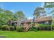 Back exterior featuring multiple decks and stairs leading into a lush green yard surrounded by mature trees at 959 Sweet Briar Se Trl, Conyers, GA 30094