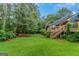Home exterior featuring a spacious backyard with lush green grass and mature trees at 959 Sweet Briar Se Trl, Conyers, GA 30094