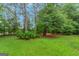 Spacious backyard with lush green grass and mature trees, perfect for outdoor activities at 959 Sweet Briar Se Trl, Conyers, GA 30094