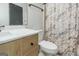 Modern bathroom with marble countertop, wooden vanity, and a shower with patterned curtain at 959 Sweet Briar Se Trl, Conyers, GA 30094