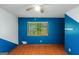 Bedroom with a window, hardwood floor, blue paint, and a ceiling fan for added comfort at 959 Sweet Briar Se Trl, Conyers, GA 30094