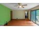 Cozy bedroom features sliding glass doors to a private balcony, ceiling fan, door to bathroom, and green accent wall at 959 Sweet Briar Se Trl, Conyers, GA 30094