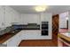 Charming kitchen featuring white cabinets, butcher block countertops, and a double oven for your cooking needs at 959 Sweet Briar Se Trl, Conyers, GA 30094