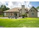 A large backyard with a patio, grill, landscaping, and a home with a chimney at 1511 Rocky Knoll Ln, Dacula, GA 30019