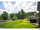 Backyard view featuring grass, a deck, outdoor furniture, and landscaping at 1511 Rocky Knoll Ln, Dacula, GA 30019