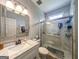 Bright bathroom featuring a marble-tiled shower and vanity with a large, decorative mirror at 1511 Rocky Knoll Ln, Dacula, GA 30019