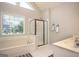 Bright bathroom featuring large tub, glass enclosed shower, large window and tiled flooring at 1511 Rocky Knoll Ln, Dacula, GA 30019