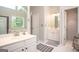 Bright bathroom featuring double sink vanity, white cabinets, large window and tiled flooring at 1511 Rocky Knoll Ln, Dacula, GA 30019