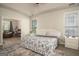 Bright bedroom featuring a queen bed, neutral walls, and two windows for natural light at 1511 Rocky Knoll Ln, Dacula, GA 30019