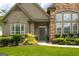 Close-up of a home's front entrance with stone accents, a manicured lawn, and a welcoming walkway at 1511 Rocky Knoll Ln, Dacula, GA 30019