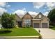 Charming home featuring stone accents, a well-manicured lawn, and a two-car garage at 1511 Rocky Knoll Ln, Dacula, GA 30019