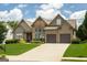 Stunning home showcasing a blend of stone and siding, complemented by lush landscaping at 1511 Rocky Knoll Ln, Dacula, GA 30019
