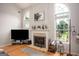 Bright living room featuring a fireplace, large arched windows, and hardwood flooring at 1511 Rocky Knoll Ln, Dacula, GA 30019