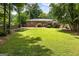 Expansive backyard features a brick home, a wooden deck, and a lush green lawn, perfect for outdoor living at 2163 Medfield Ne Trl, Chamblee, GA 30345