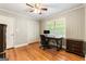 Comfortable bedroom showing hardwood floors, a ceiling fan, and a window overlooking trees at 2163 Medfield Ne Trl, Chamblee, GA 30345