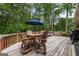 Spacious wooden deck with outdoor seating, including a table, chairs, and a large blue umbrella at 2163 Medfield Ne Trl, Chamblee, GA 30345