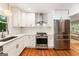 Well-lit kitchen boasts stainless steel appliances, white cabinetry and hardwood floors at 2163 Medfield Ne Trl, Chamblee, GA 30345