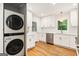 Modern kitchen featuring new appliances, including a stainless steel dishwasher and stacked washer and dryer at 2163 Medfield Ne Trl, Chamblee, GA 30345