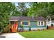 Charming home featuring a bright red front door and quaint, cottage-style landscaping and a concrete driveway at 1258 Campbellton Sw Rd, Atlanta, GA 30310