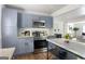 Modern kitchen with light-blue cabinets, stainless steel appliances, and a functional layout open to the living area at 1258 Campbellton Sw Rd, Atlanta, GA 30310