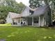 Back exterior of house featuring covered porch and manicured lawn at 149 Crown Oaks Dr, Stockbridge, GA 30281