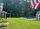 Fenced in in-ground pool with manicured lawn and wooded backdrop at 149 Crown Oaks Dr, Stockbridge, GA 30281