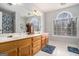 Bright bathroom featuring a double vanity, decorative clock, and arched window at 149 Crown Oaks Dr, Stockbridge, GA 30281