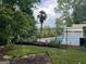 View of fenced in pool, wooded lot and mature palm trees at 149 Crown Oaks Dr, Stockbridge, GA 30281