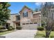 Charming home featuring a stone facade, a two-car garage, and lush landscaping at 2780 Lakeview Walk, Decatur, GA 30035