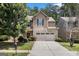 Charming home featuring a stone facade, a two-car garage, and lush landscaping at 2780 Lakeview Walk, Decatur, GA 30035
