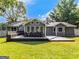 Well-manicured backyard features a spacious deck with built-in seating, a grill and mature trees at 30 Court, Ellenwood, GA 30294