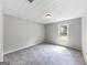 This minimalist bedroom features neutral carpet, soft gray walls, and a window at 30 Court, Ellenwood, GA 30294